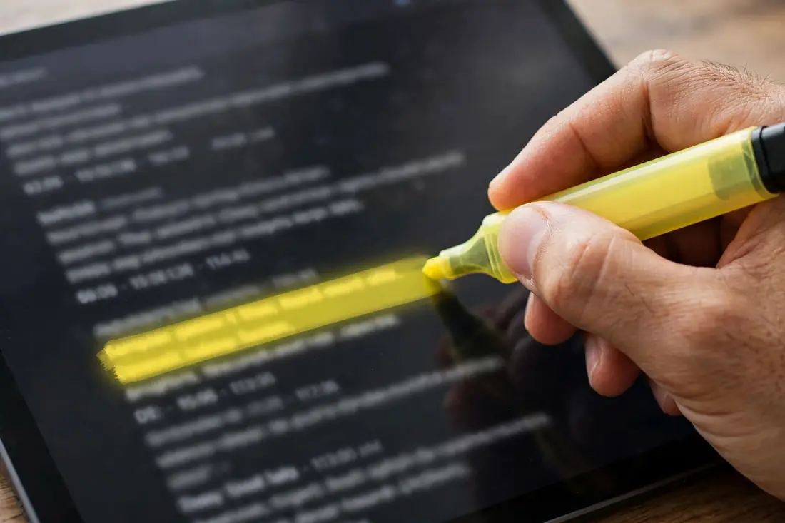 Hand highlighting a YouTube video transcript on a tablet